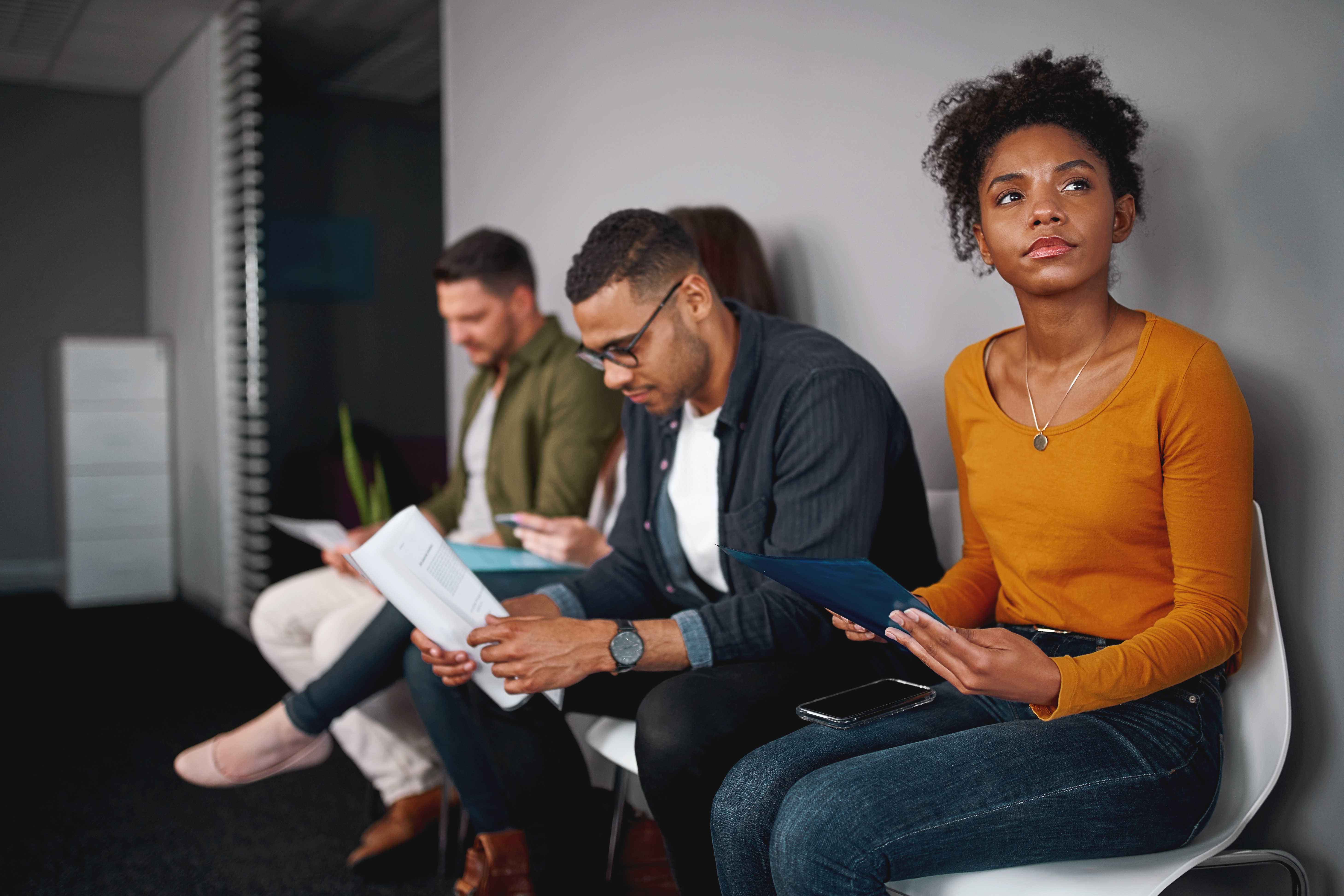 four job candidates sitting waiting for an interview